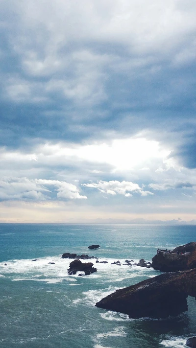 Dramatic Ocean Scenery with Rocky Outcrops Under Cloudy Sky