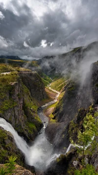 Majestätischer Wasserfall, der durch neblige Bergtäler stürzt