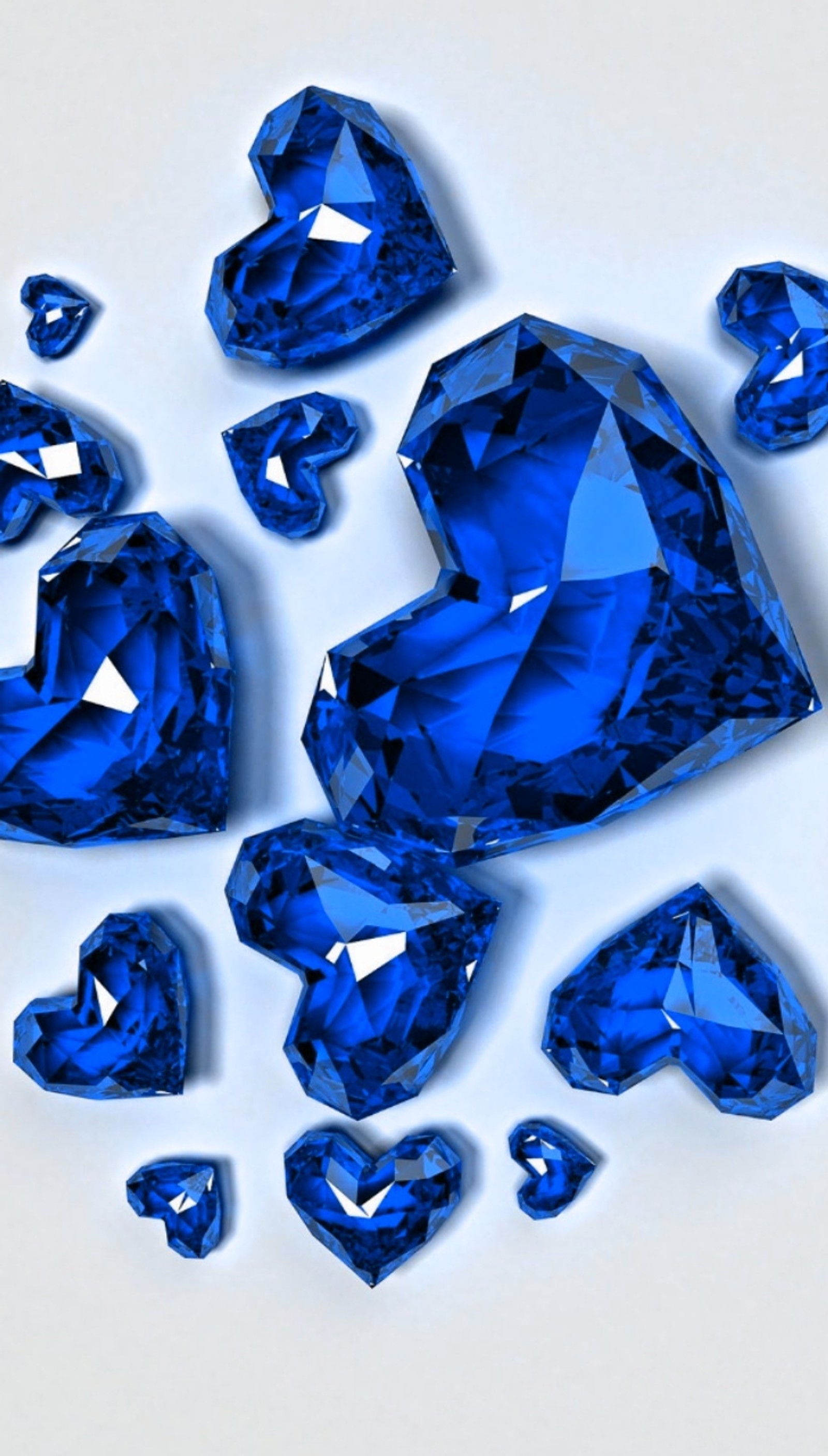 A close up of a bunch of blue diamonds on a white surface (diamonds, hearts, sapphire, blue)