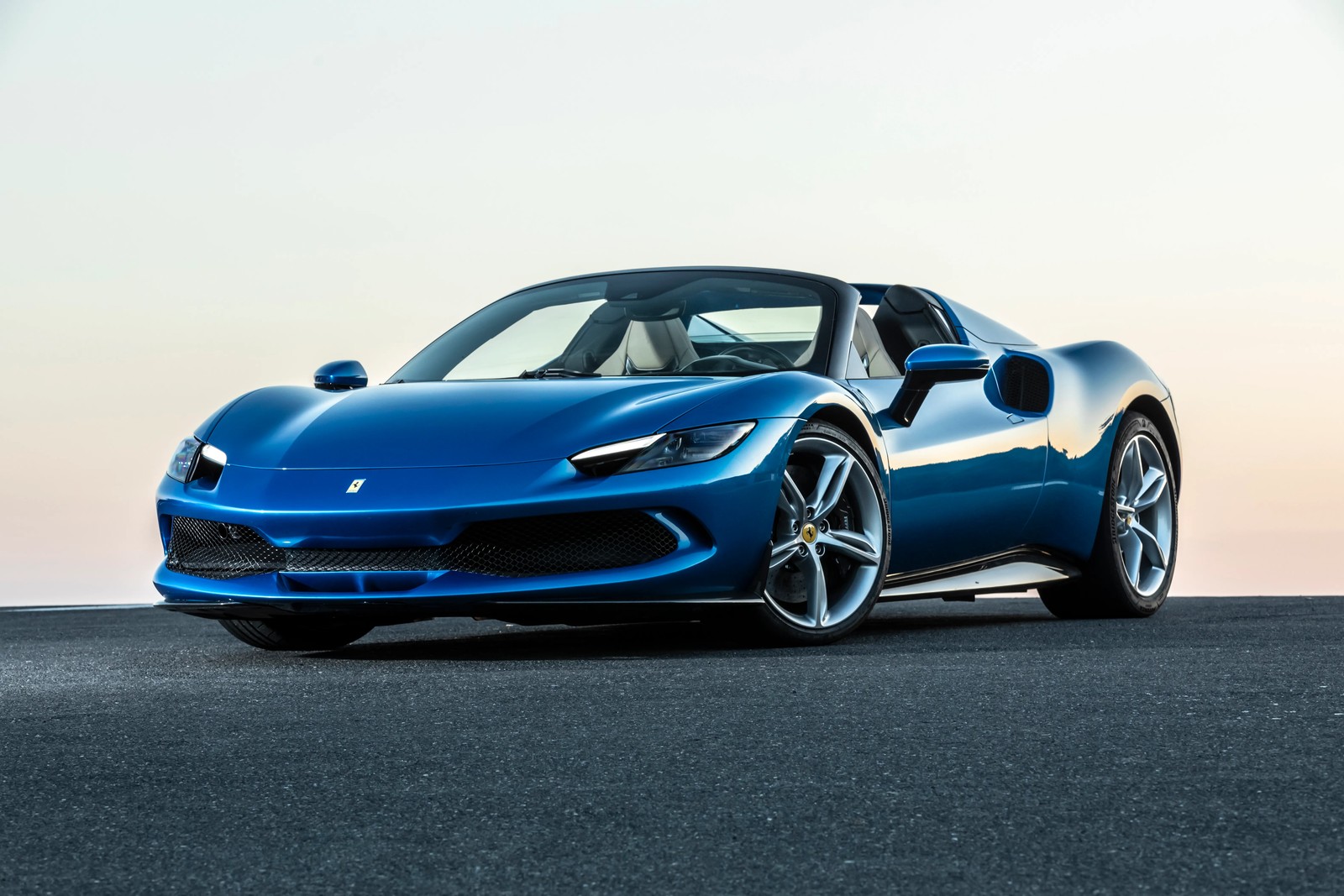 Un coche deportivo ferrari azul estacionado en una carretera cerca del océano (ferrari 296 gts, supercoches, 2022, 5k, coches)