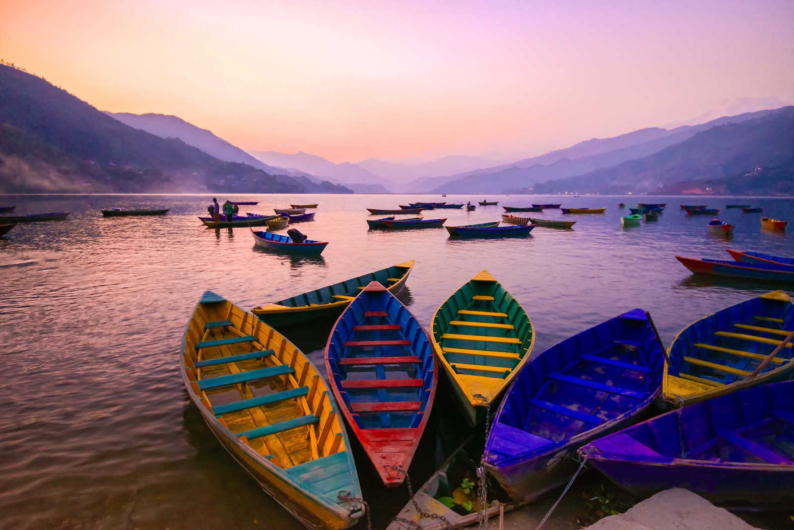 Vários barcos estão alinhados na água ao pôr do sol (viagem, transporte aquático, barco, lago, reflexo)