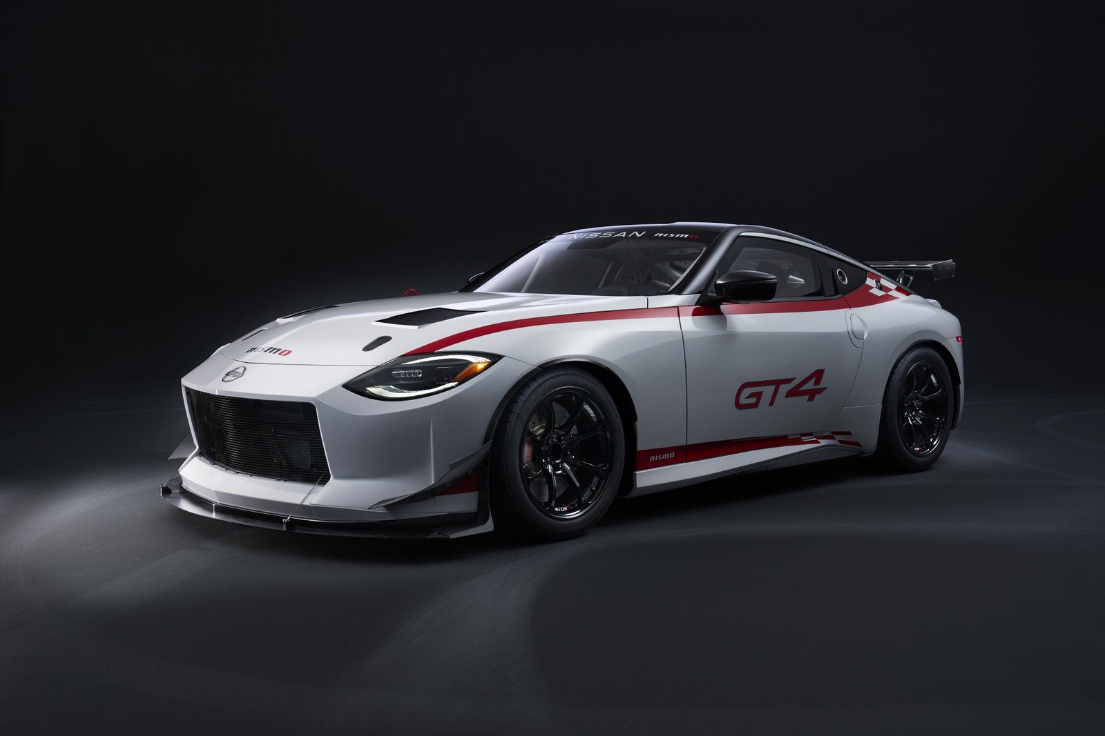 El coche de carreras nissan gt4 se muestra en un estudio (nissan z gt4, coches de carreras, coches deportivos, fondo oscuro, 5k)