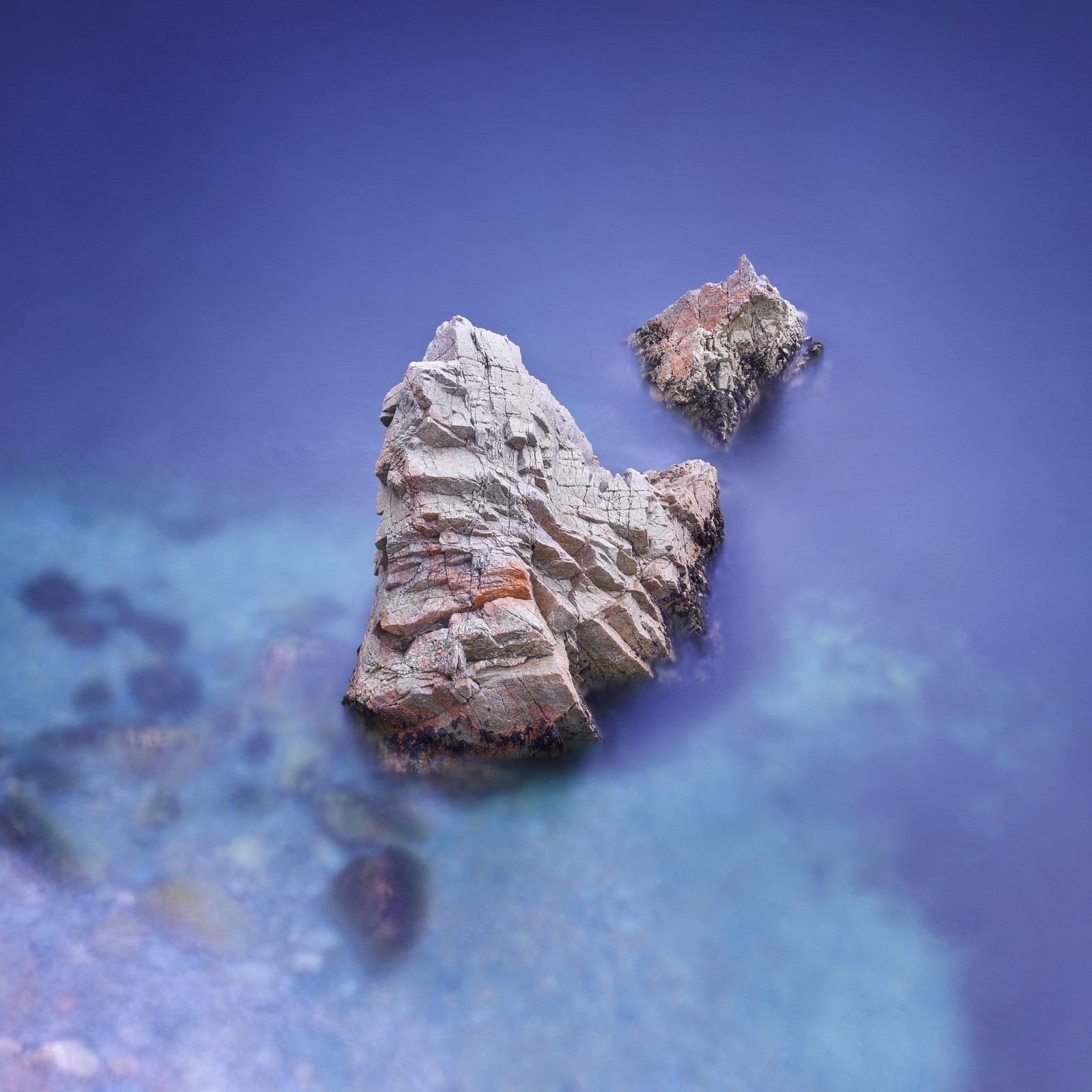 Il y a deux rochers dans l'eau près du rivage (pommes, apple macbook pro, socle, paysage naturel, bois)