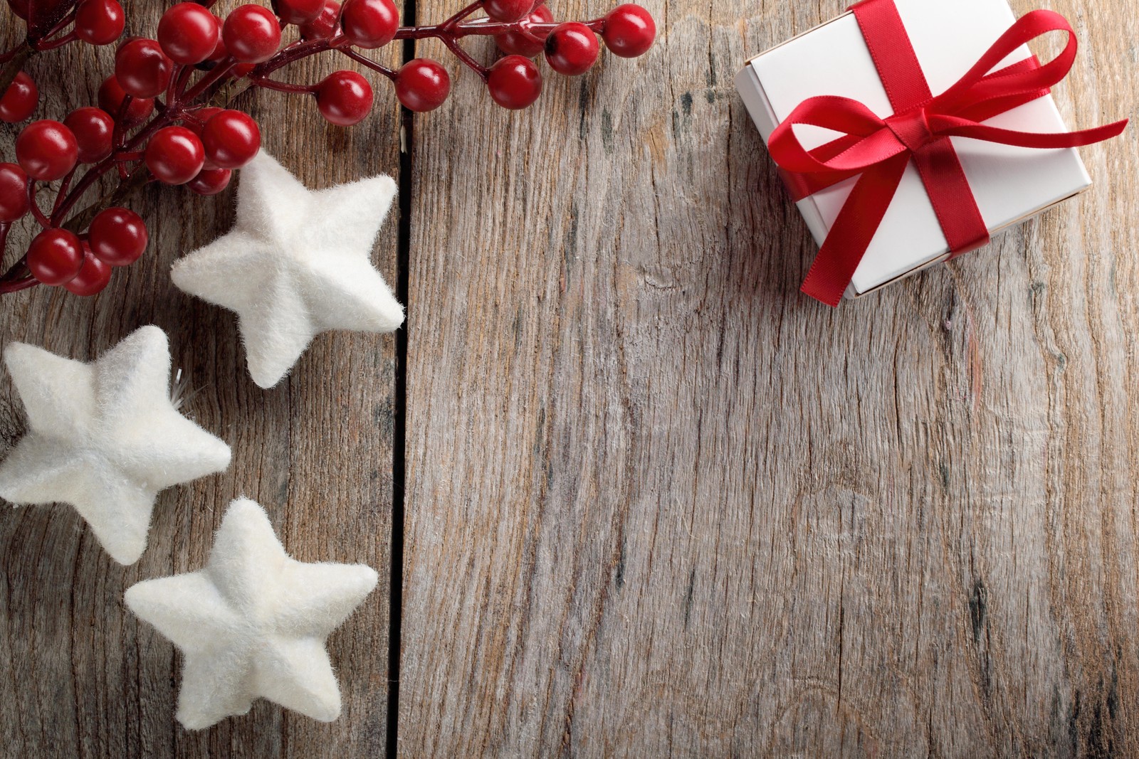 Um close em uma caixa de presente com um laço vermelho e estrelas (dia de natal, enfeite de natal, ornamento de natal, natal, madeira)