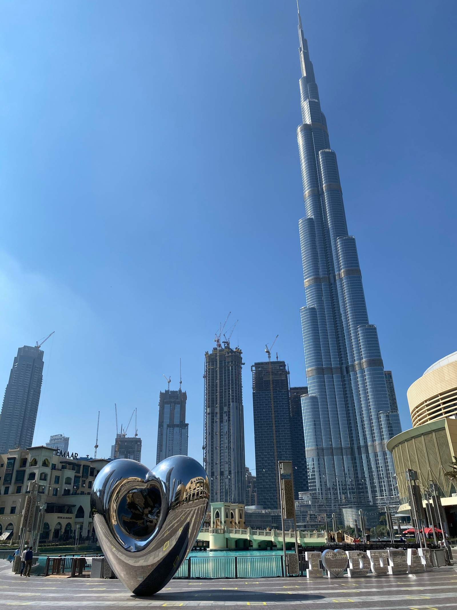 Escultura en forma de corazón frente a un edificio alto (dubái, dubai, burj khalifa, rascacielos, día)