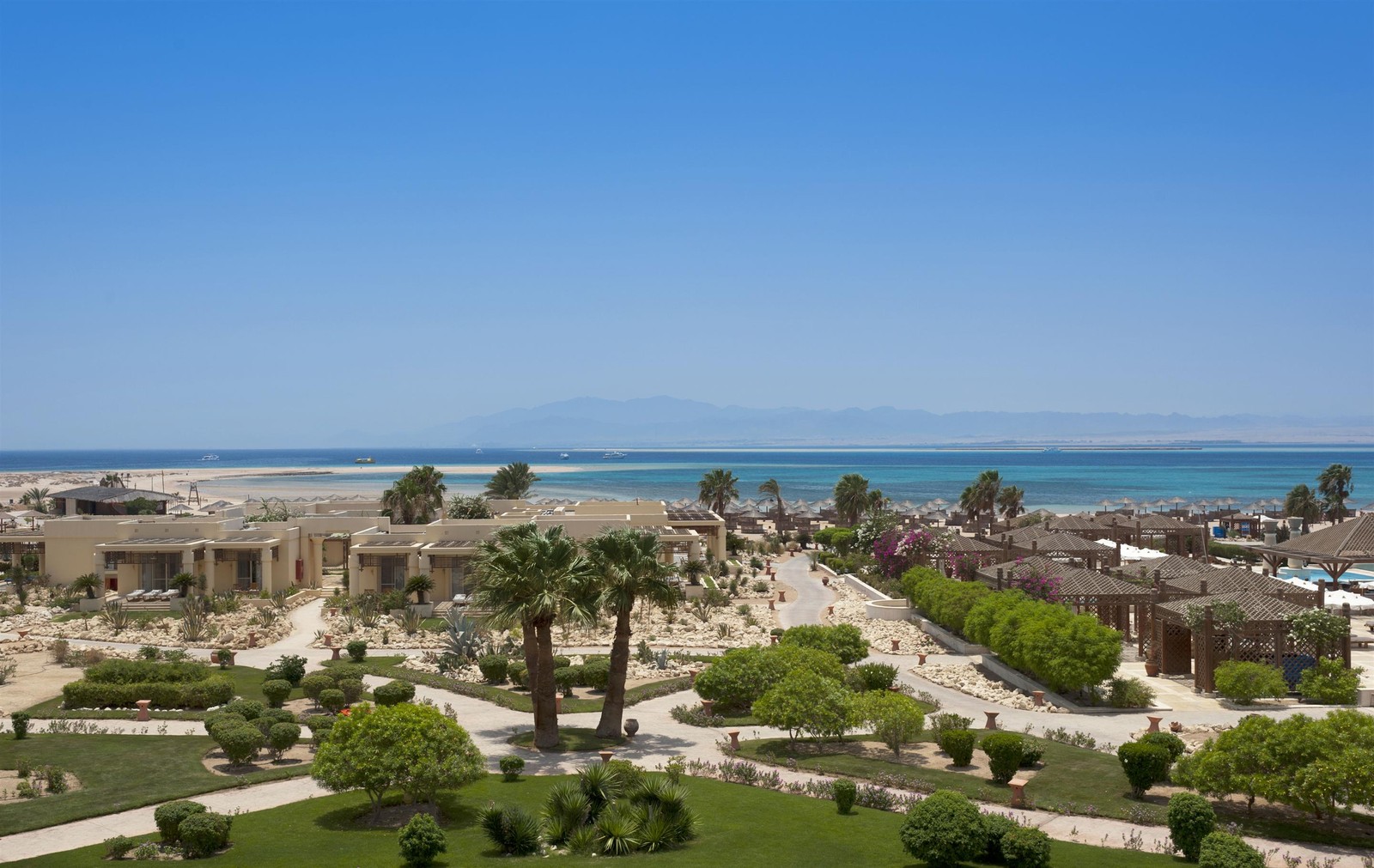 Vista aérea de um resort de praia com uma palmeira e uma piscina (praia, estância, mar, costa, horizonte)