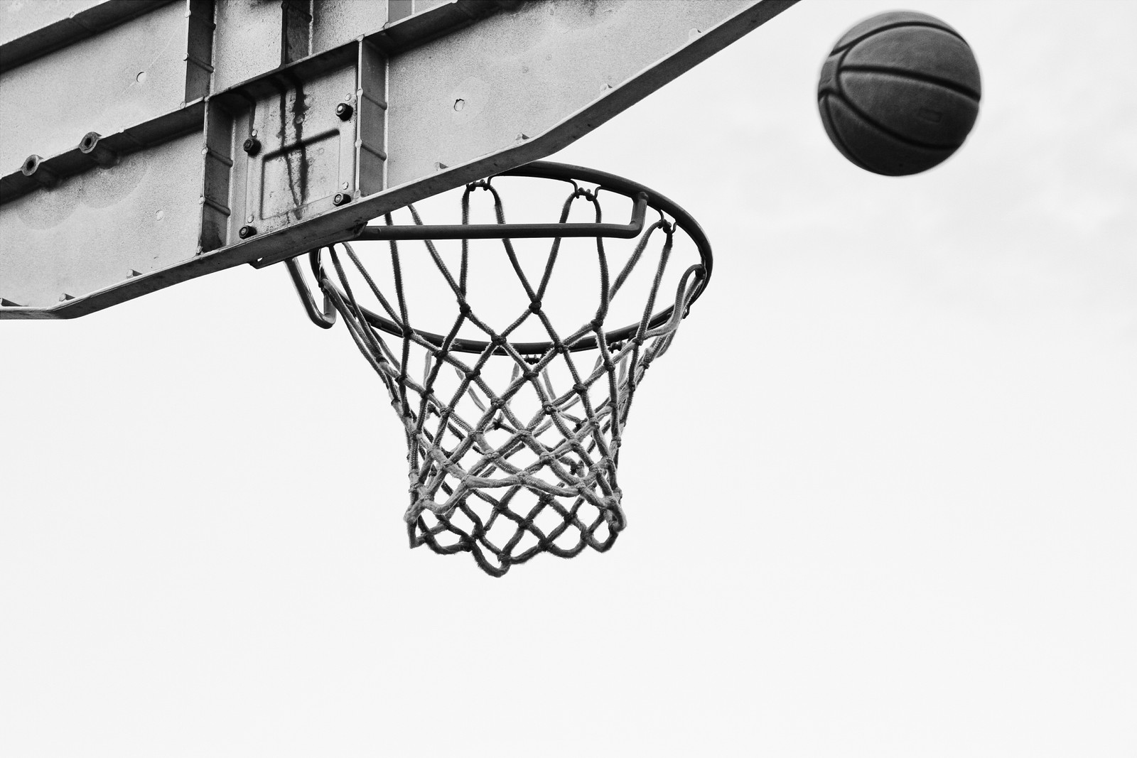 Una pelota de baloncesto entrando en la canasta de una cancha de baloncesto (baloncesto, tablero de respaldo, cancha de baloncesto, streetball, deporte de equipo)