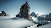 Majestosas montanhas cobertas de neve se erguendo acima de um mar de nuvens