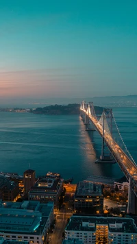 Paisagem urbana de São Francisco ao crepúsculo: Ponte da Baía iluminada e águas tranquilas