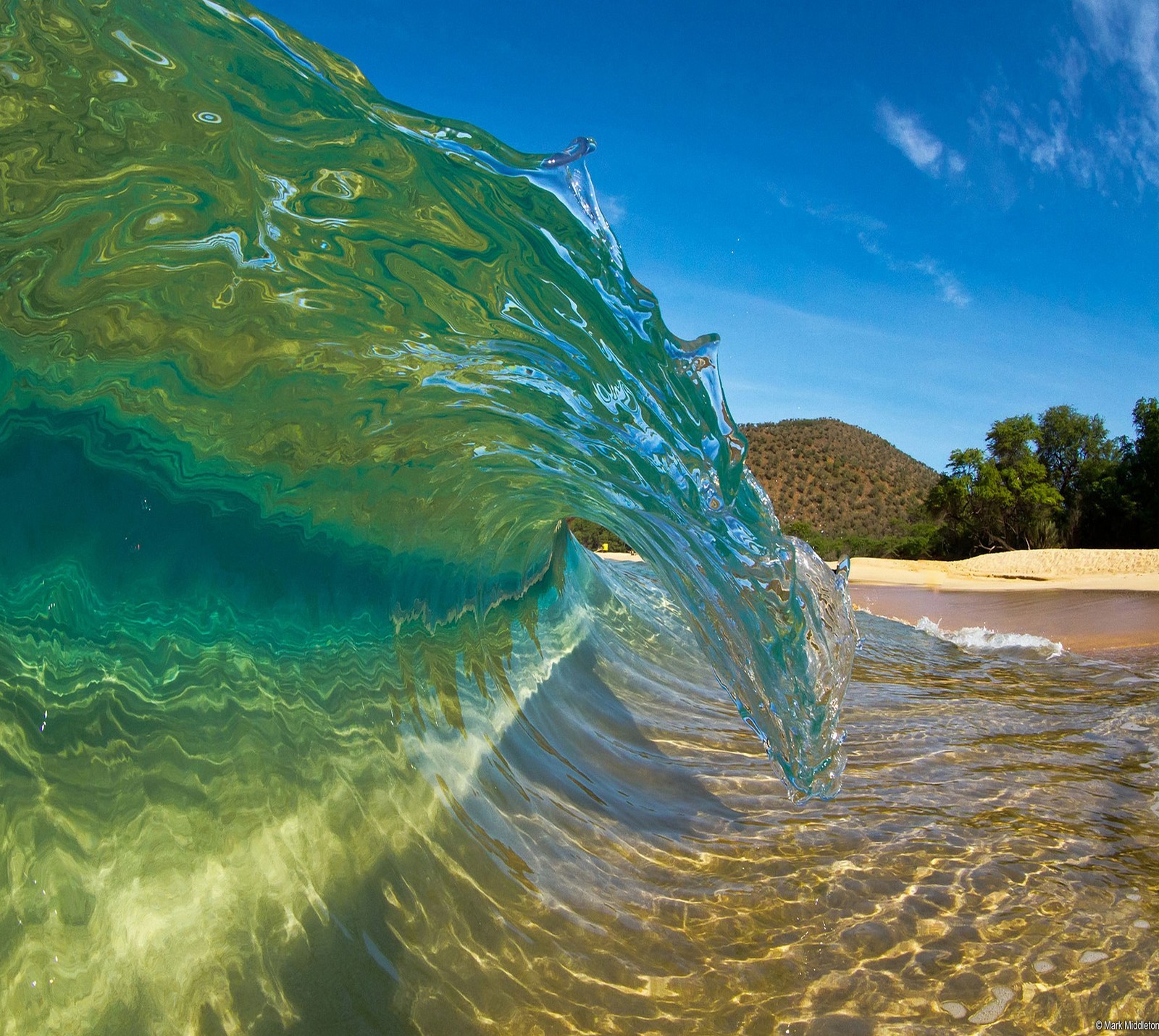 A close up of a wave breaking on a beach with a blue sky (abej, beograd, wave)