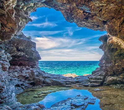 Stunning Sea Cave Overlooking Tranquil Waters and Blue Skies