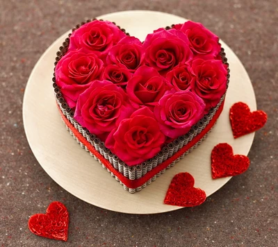 Heart-shaped arrangement of vibrant red roses on a wooden platter, surrounded by decorative red hearts.