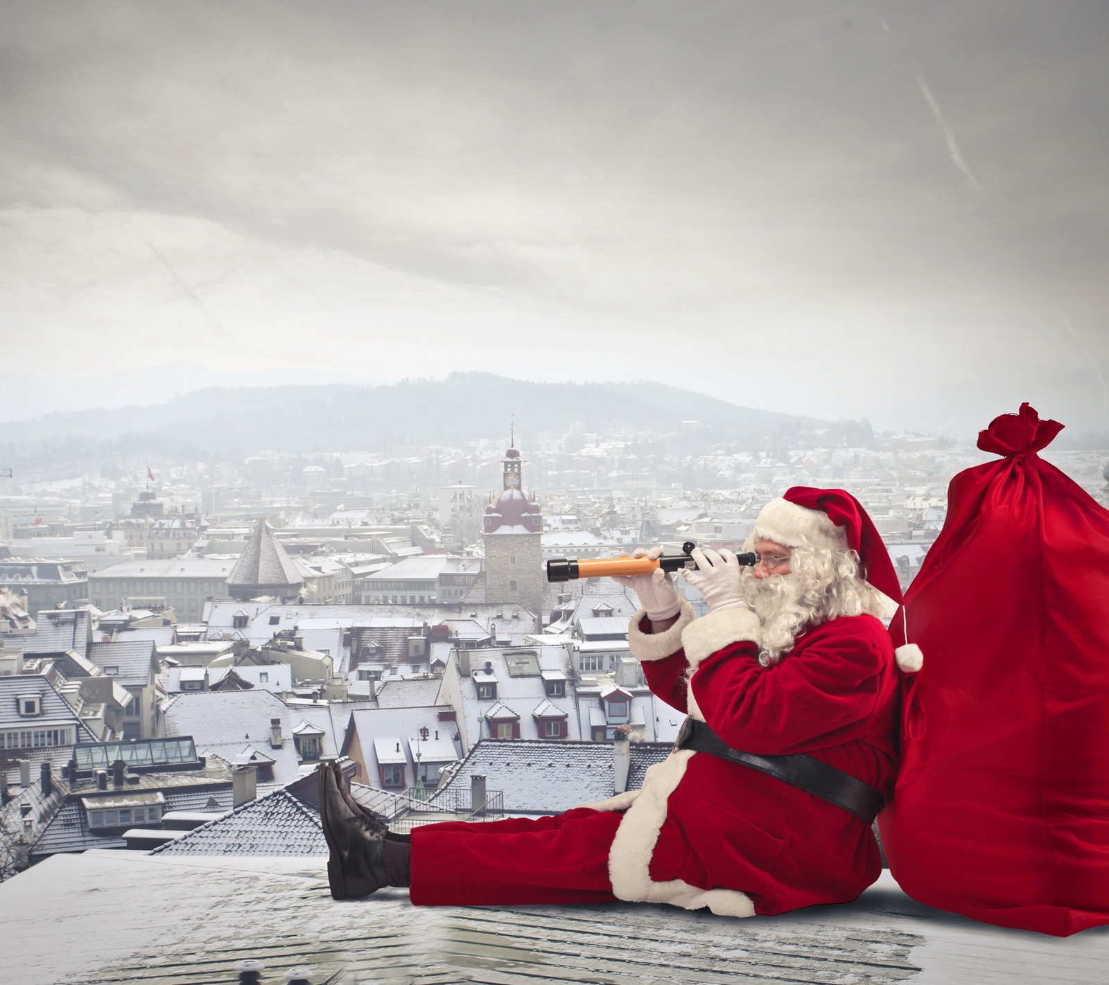 Le père noël assis sur un toit regardant une ville à travers un télescope (maison hiver, père noël, ville)