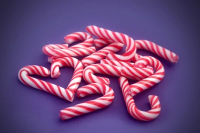 Festive Heart-Shaped Candy Canes on Purple Background