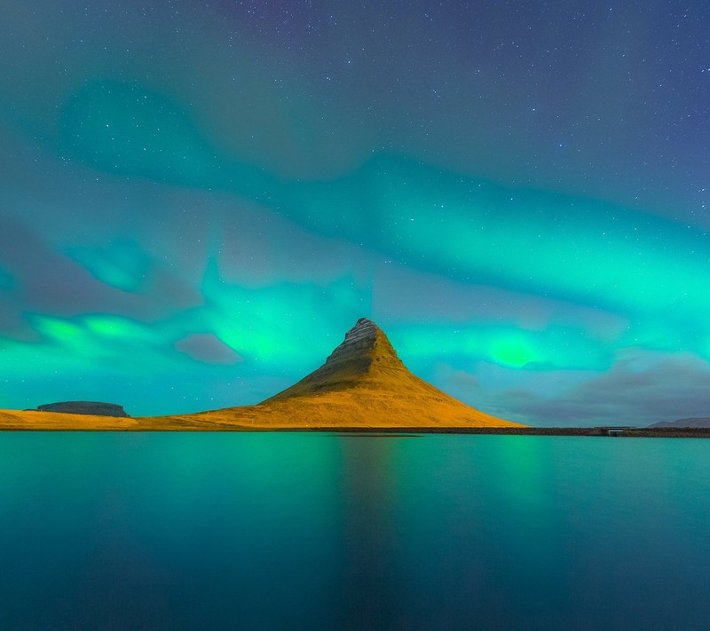 A view of a mountain with a green aurora lights in the sky (blue, lake, mountain, nature)