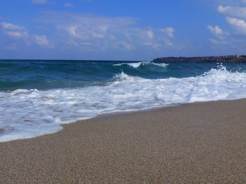 Волна накатывается на пляж с человеком в воде (пляж, море, лето)