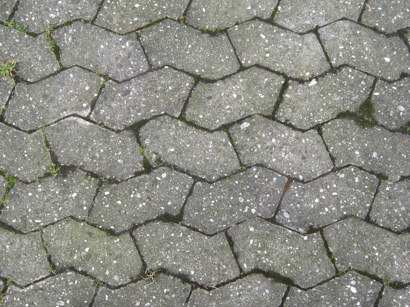 Un primer plano de una acera con un montón de bloques de cemento (superficie de la carretera, roca, muro de piedra, suelo, azulejo)