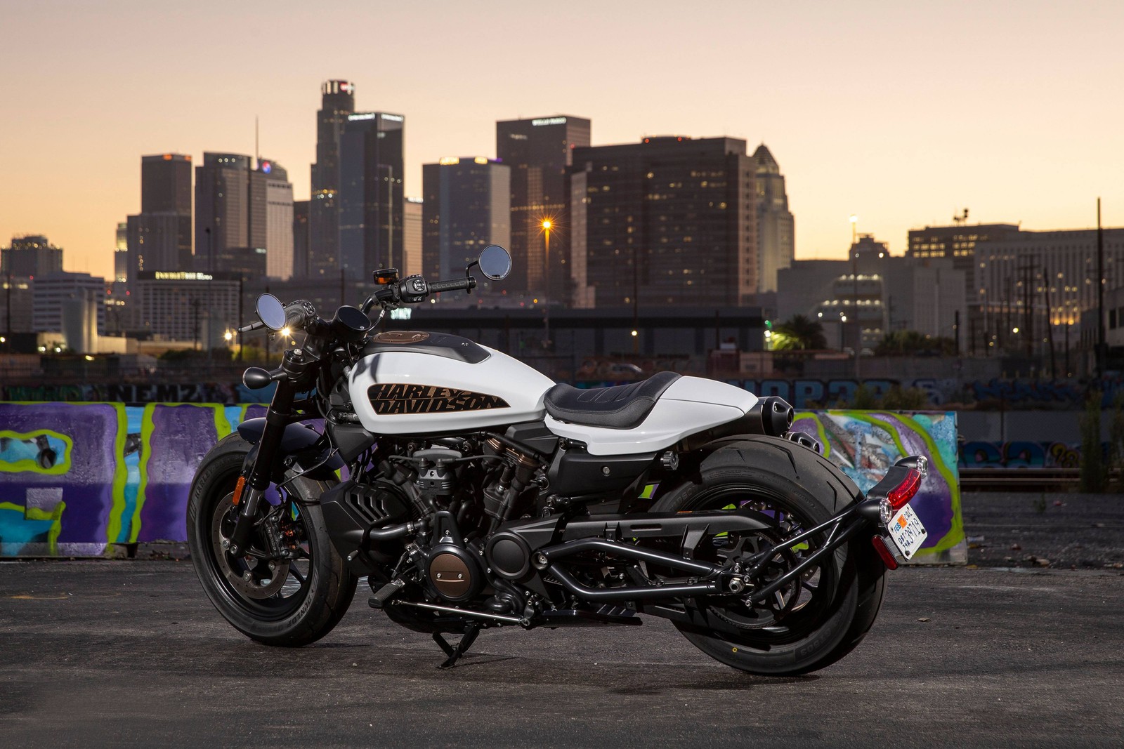 Una motocicleta árabe estacionada frente a un horizonte urbano al atardecer (harley davidson sportster s, bicicleta de rendimiento, 2021, bicicletas, fondo de pantalla 4k)