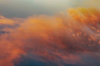 Abendhimmel mit orangefarbenem Nachglühen und sanften Wolken