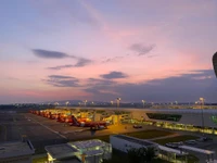 Brilho da noite sobre o aeroporto urbano com nuvens ao crepúsculo