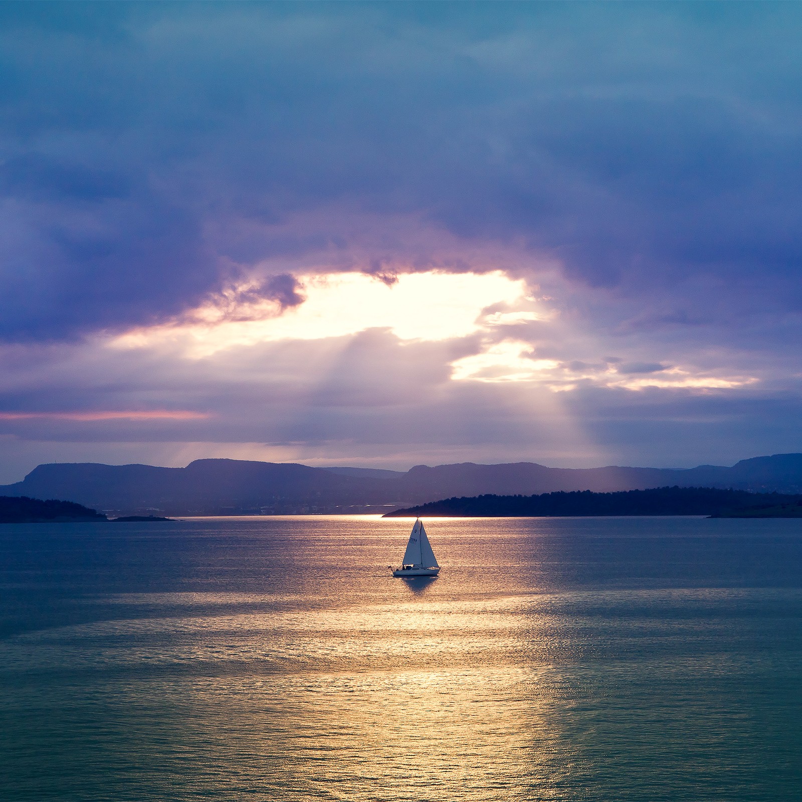 Un voilier arafed dans l'océan avec un rayon de soleil en arrière-plan (nuage, eau, ressources en eau, atmosphère, bateau)