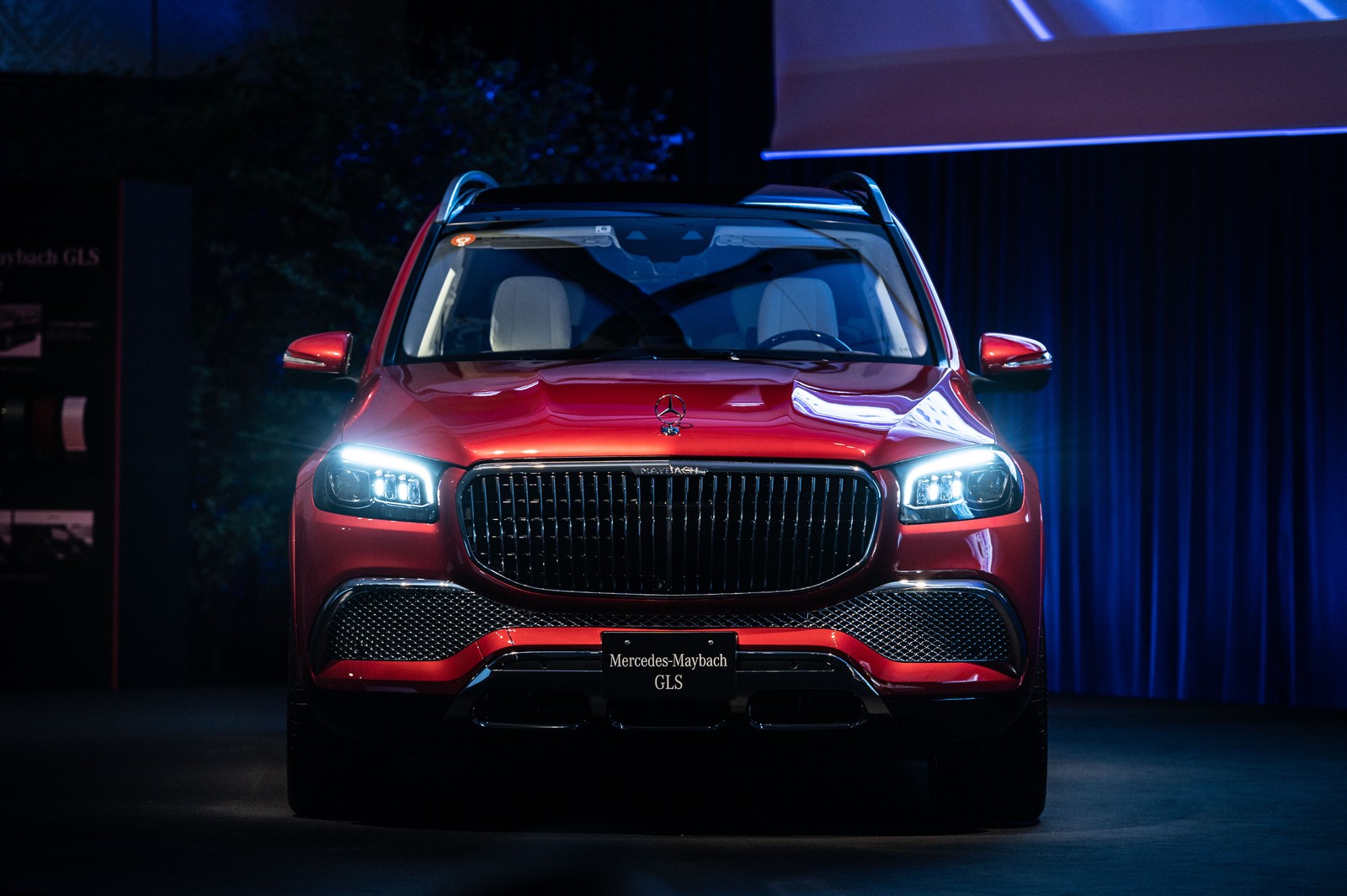 A close up of a red suv on a stage with a blue curtain (mercedes maybach gls 600 4matic, luxury suv, 2021, 5k, cars)