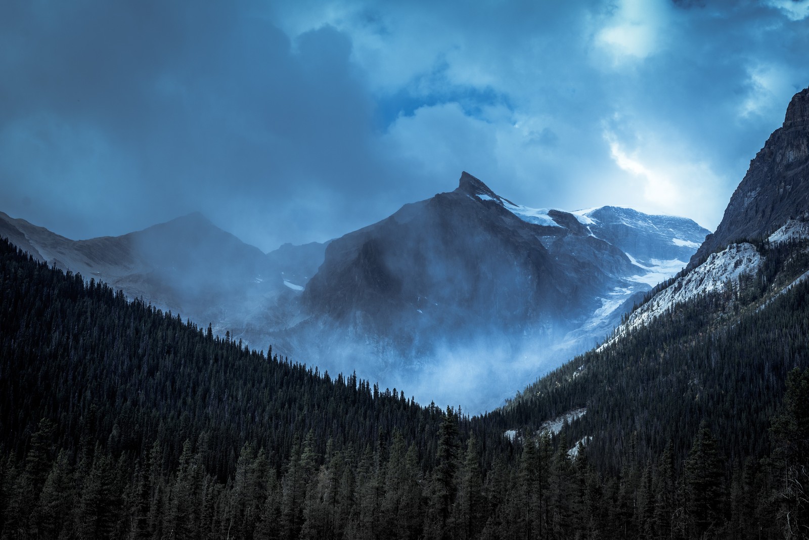 Aussicht auf ein gebirge mit wald und bewölktem himmel (yoho nationalpark, kanada, gebirgskette, nebelberge, schneebedeckt)