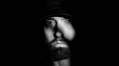 Retrato monocromático de Eminem na sombra contra fundo preto