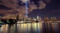 Paisagem urbana noturna: reflexos da Ponte do Brooklyn e arranha-céus sob feixes iluminados