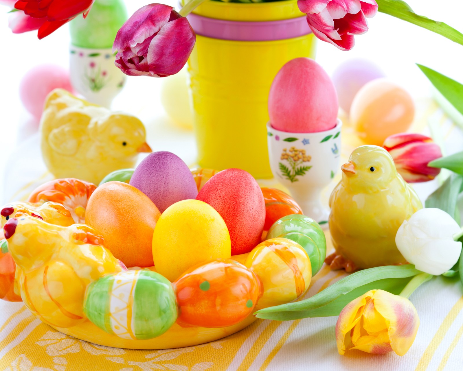 There are many colorful easter eggs in a yellow bowl with flowers (easter egg, food, easter, sweetness, confectionery)