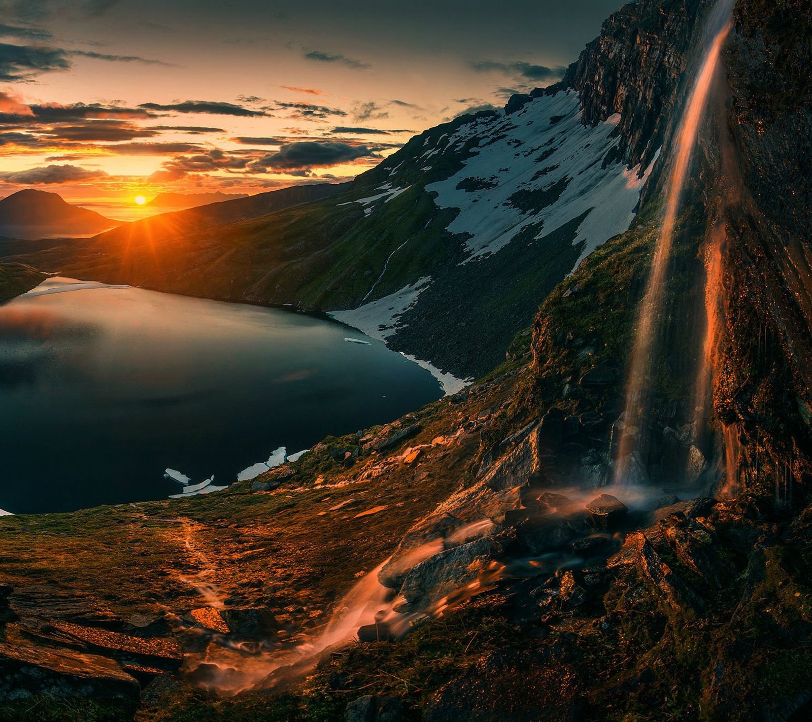 Una vista de una cascada en medio de una montaña con un lago abajo (asombroso, naturaleza, atardecer, cascada)