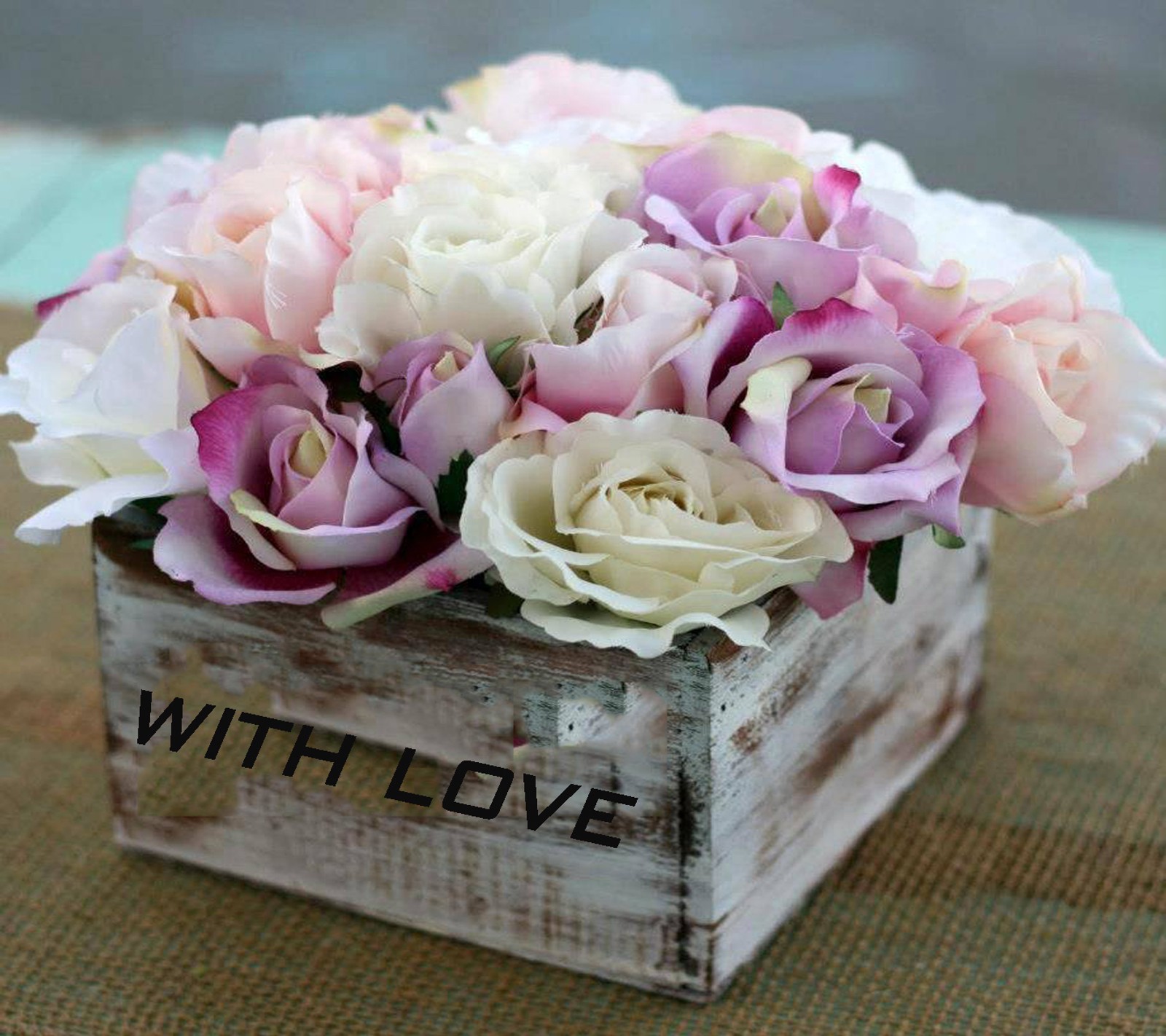 There is a wooden box with flowers in it on a table (love, with)