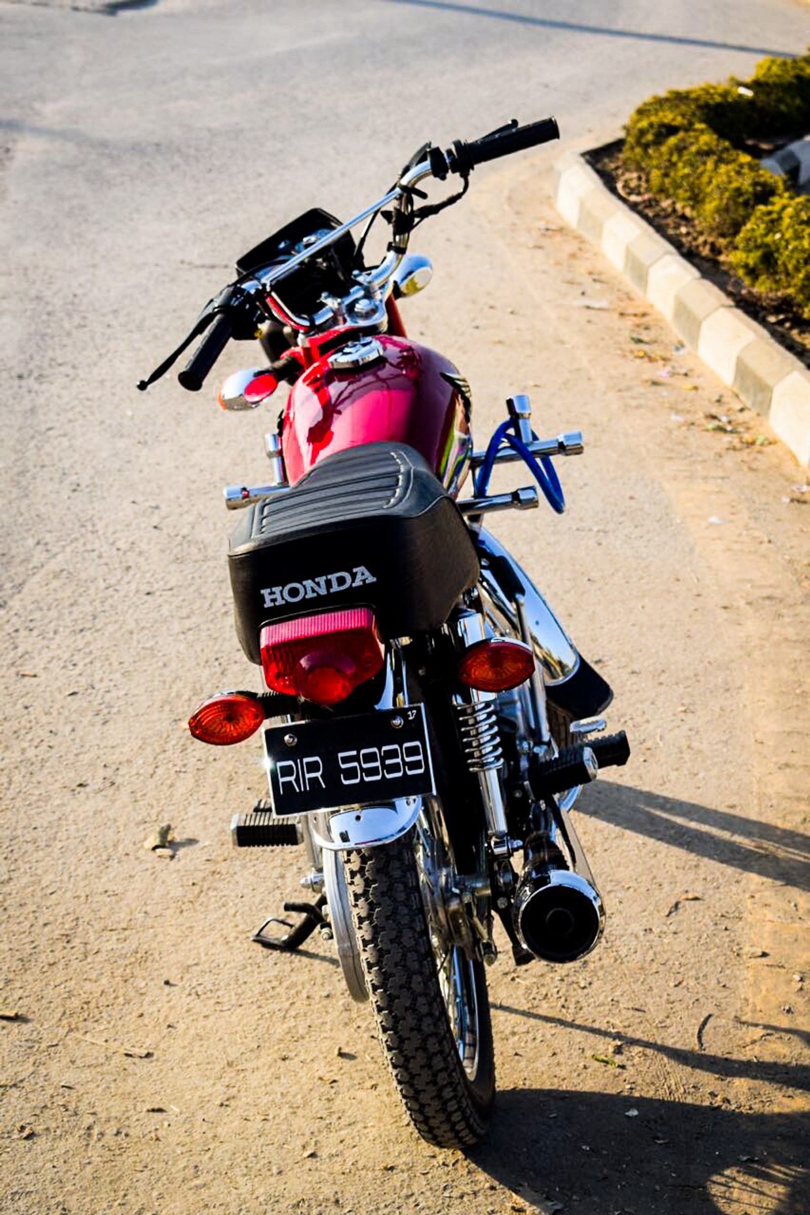 Une moto est garée sur le bord de la route. (vélo, honda)