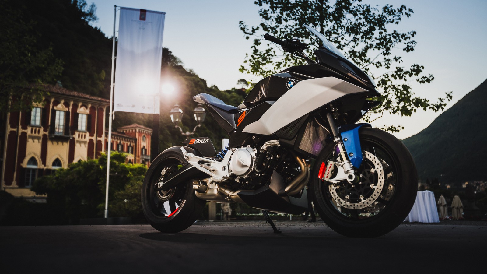 A close up of a motorcycle parked on a street near a building (motorcycle, sport bike, tire, wheel, automotive tire)