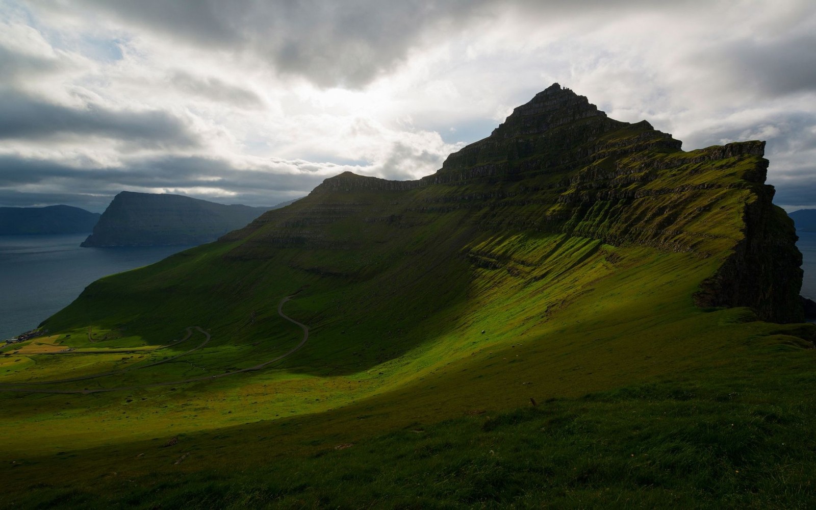 Ein blick auf einen berg mit einer straße, die hindurchführt (natur, hügel, landschaft, küste, wolke)