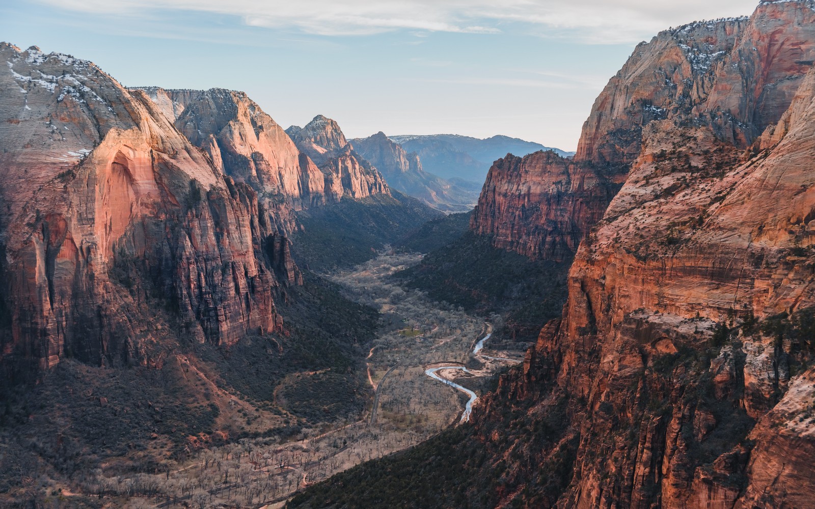 Uma vista de um cânion com uma estrada sinuosa no meio (parque nacional de zion, zion national park, parque nacional bryce canyon, parque nacional arches, grand canyon)