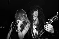 Axl Rose et Slash se produisant avec passion sur scène lors de la tournée "Not in This Lifetime", capturés en noir et blanc saisissant.