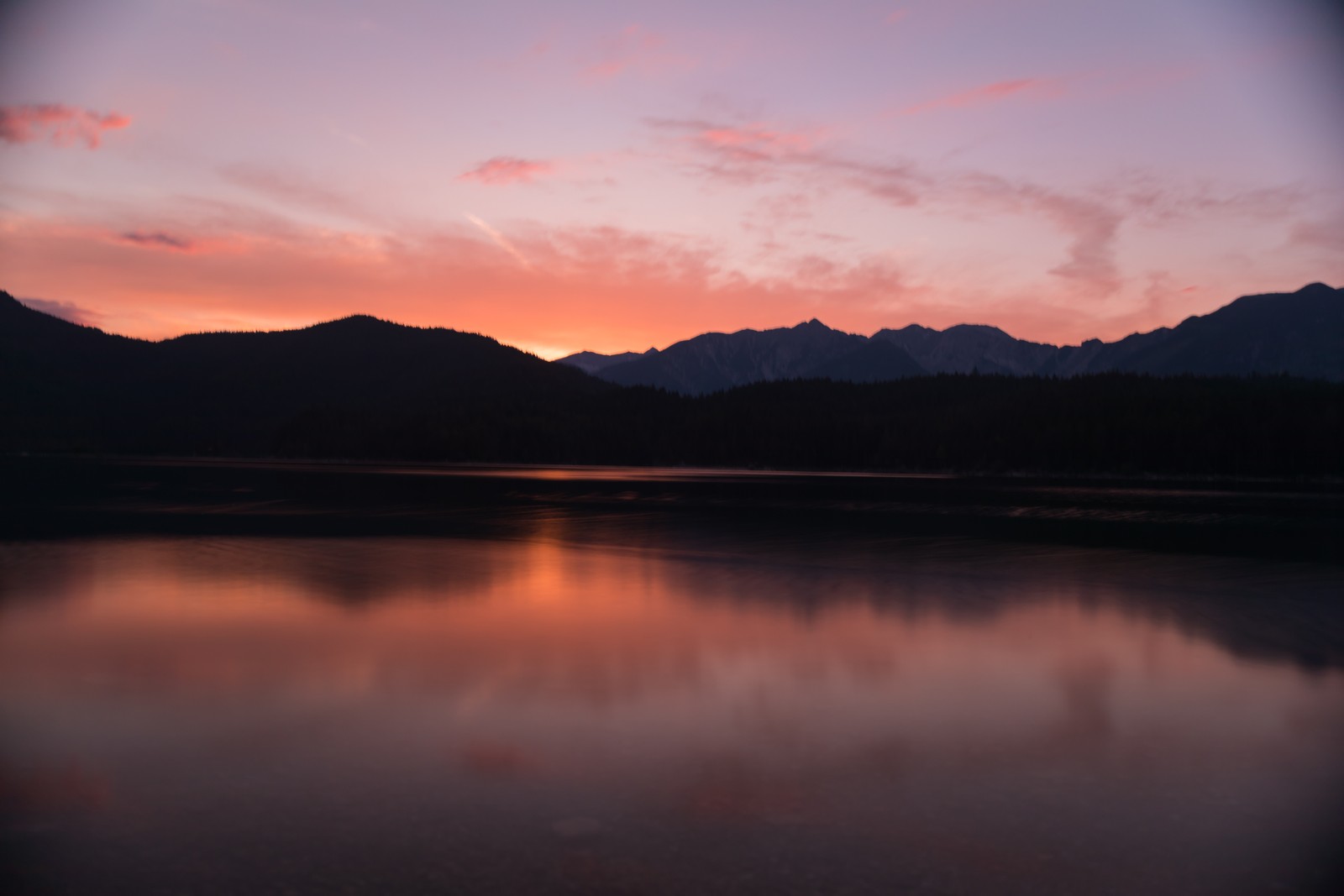 Vista aérea de um lago com montanhas ao fundo (reflexo, natureza, resplendor, nuvem, horizonte)