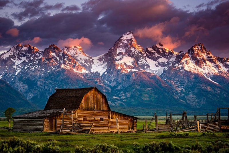 Деревянный сарай на поле с горами на заднем плане (гранд тетон, grand teton, джексон хоул, jackson hole, национальный парк)