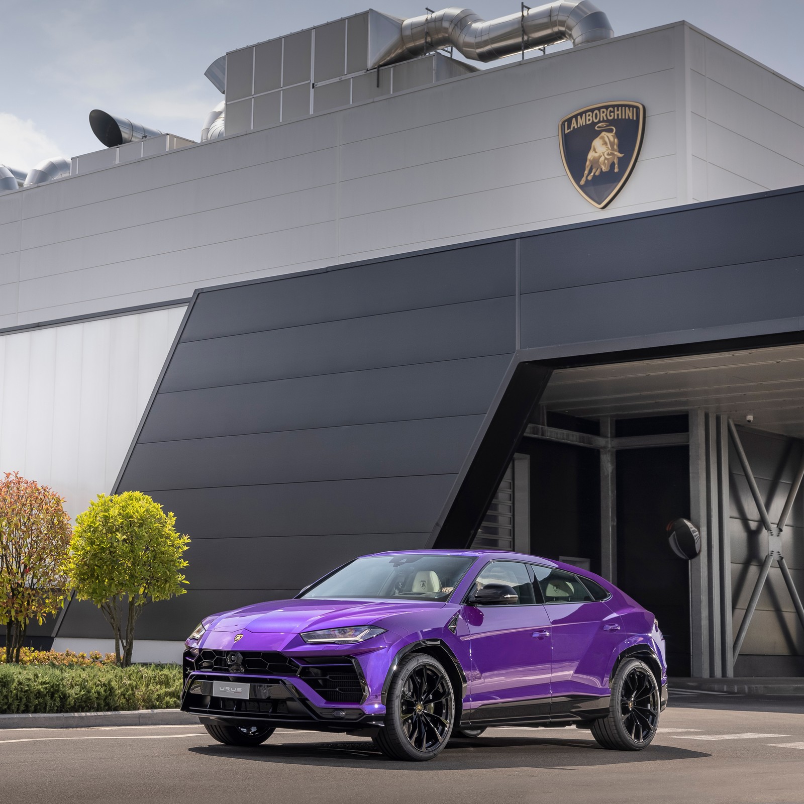 O lamborghini urus suv está estacionado em frente a um edifício com exterior roxo (lamborghini urus, carros, papel de parede 4k)