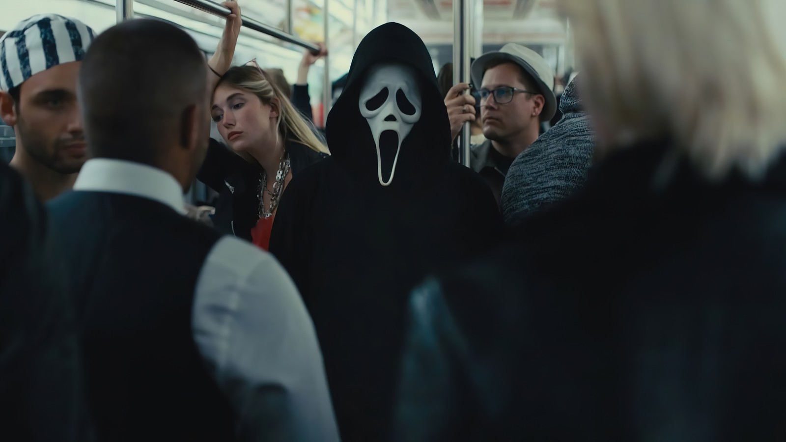 Uma imagem árabe de um grupo de pessoas em um metrô com um homem de máscara (scream vi, scream 6, 2023, filme)