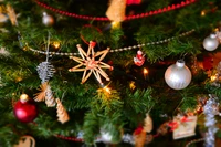 Arbre de Noël décoré de manière festive avec des ornements traditionnels et des décorations créatives.