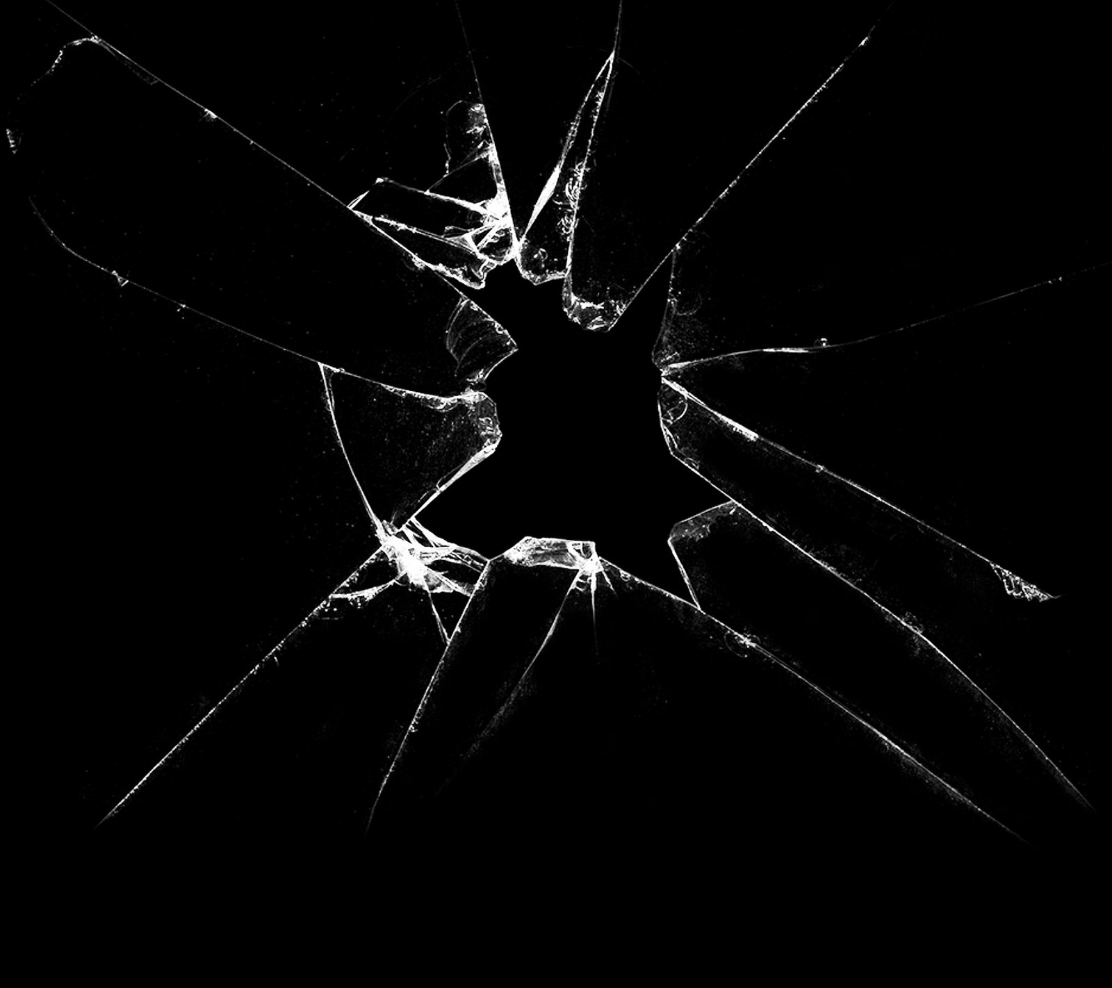 A close up of a broken glass window with a black background (cracked, cracked screen, fun, glass, hole)