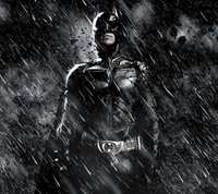 Batman está de pé, resoluto na chuva, exalando força e determinação contra um fundo escuro.