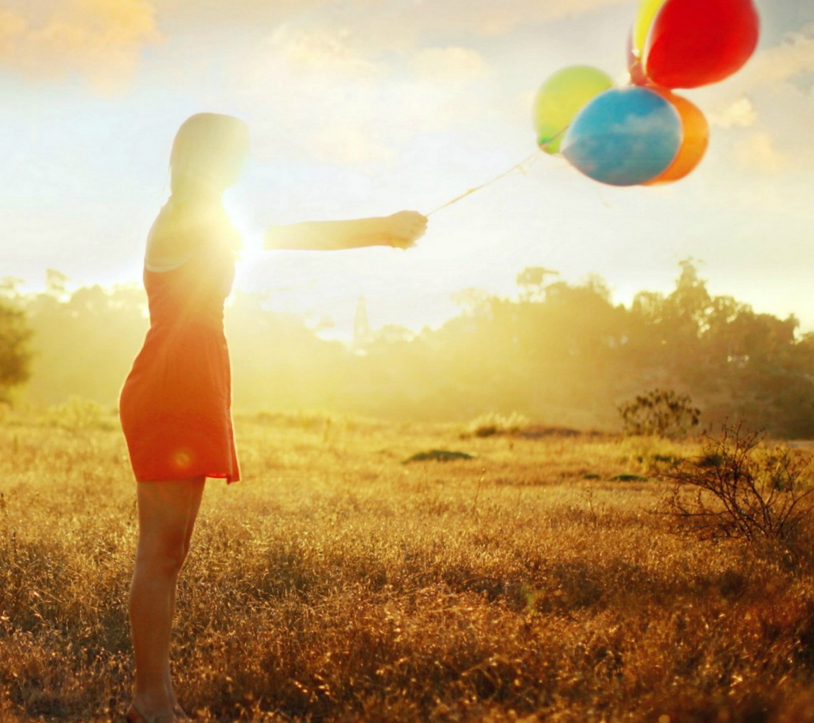 Eine frau, die einen haufen ballons auf einem feld hält (abstrakt, luftballons, mädchen)