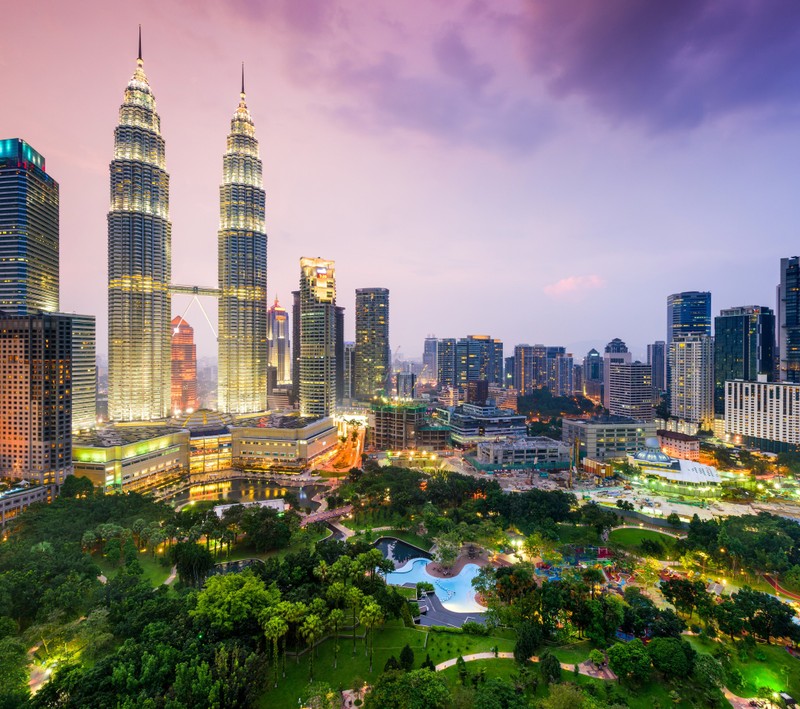 Арабский вид на башни петронас и город на закате (кuala lumpur, малайзия, петронас, небоскребы, деревья)