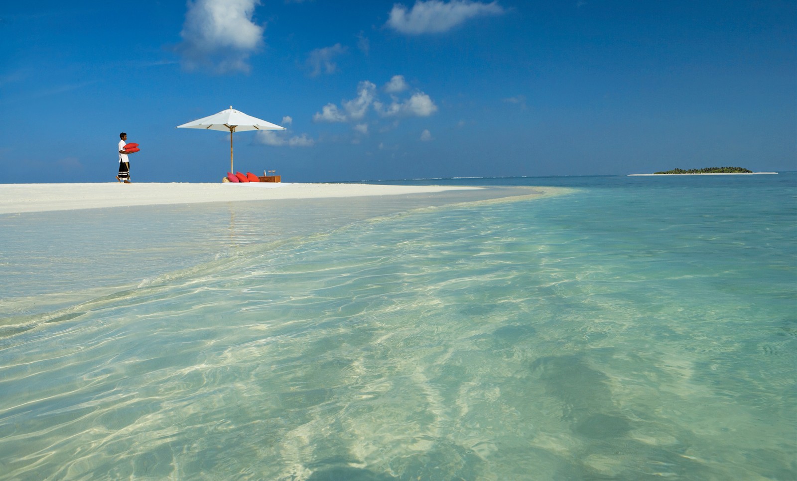 Ein mann steht am strand mit einem sonnenschirm (strand, insel, resort, atoll, meer)