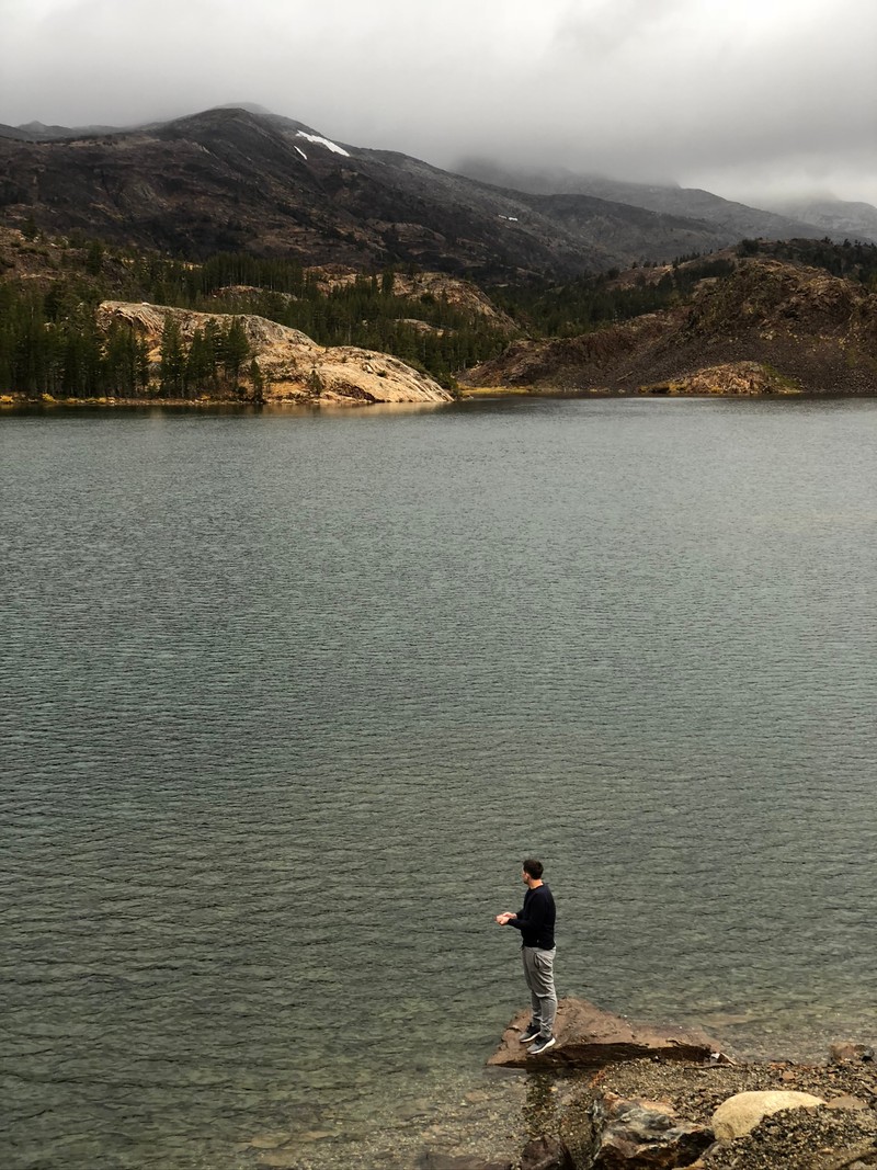 Мужчина стоит на скале у воды (вода, озерный край, lake district, горные образования, водные ресурсы)