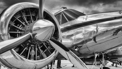 Close-up de uma hélice e motor de avião vintage em preto e branco.