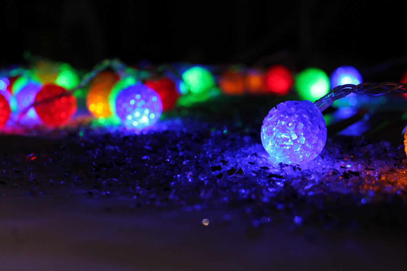 Bunt leuchtende lichter sind an einer lichterkette in der dunkelheit (neues jahr, nacht, licht, beleuchtung, wasser)